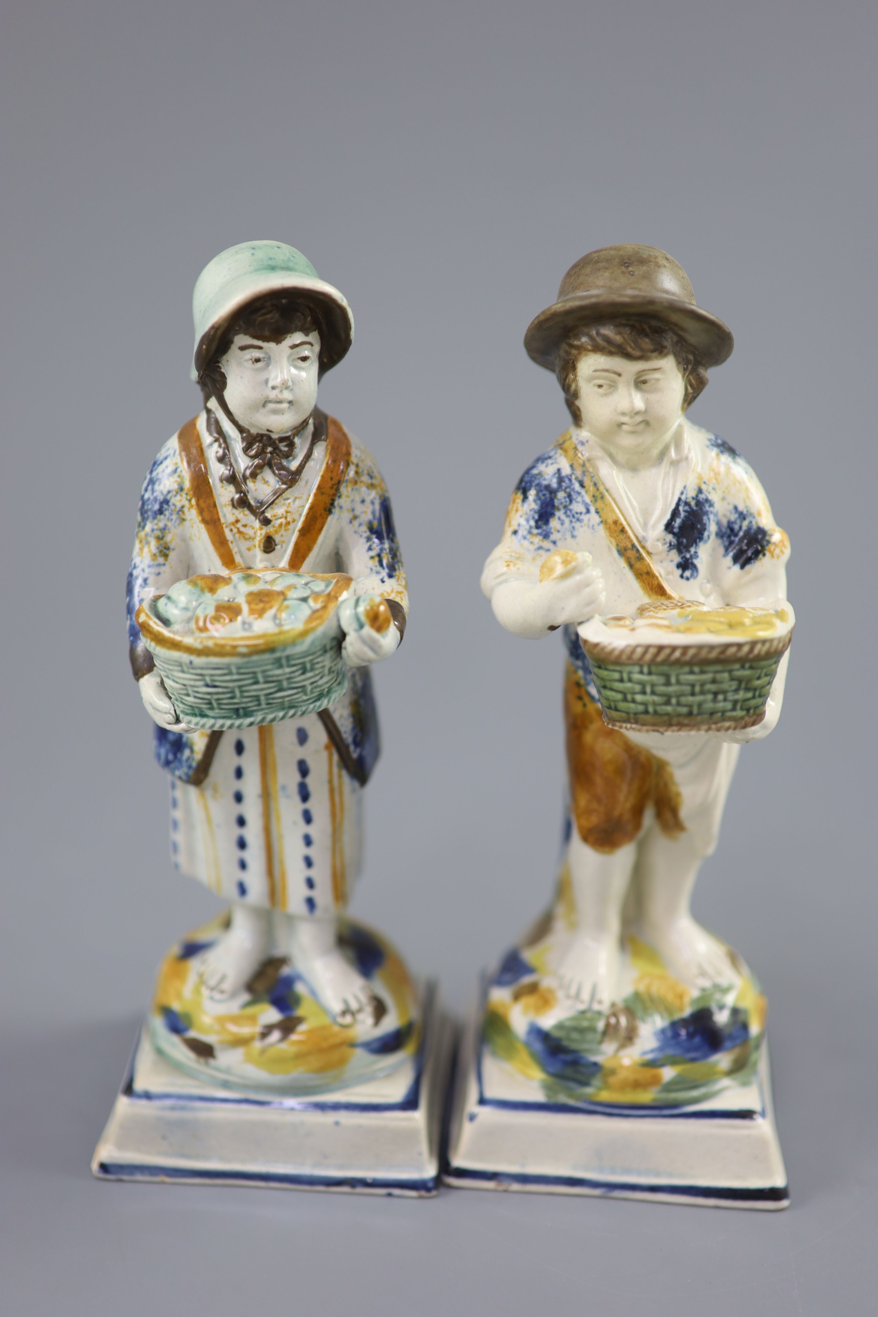 A pair of Prattware figures of fruit and biscuit street vendors, c.1790-1800, 17.5cm high